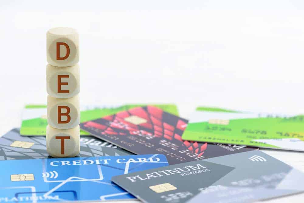 A number of credit cards and dices forming the word "debt"