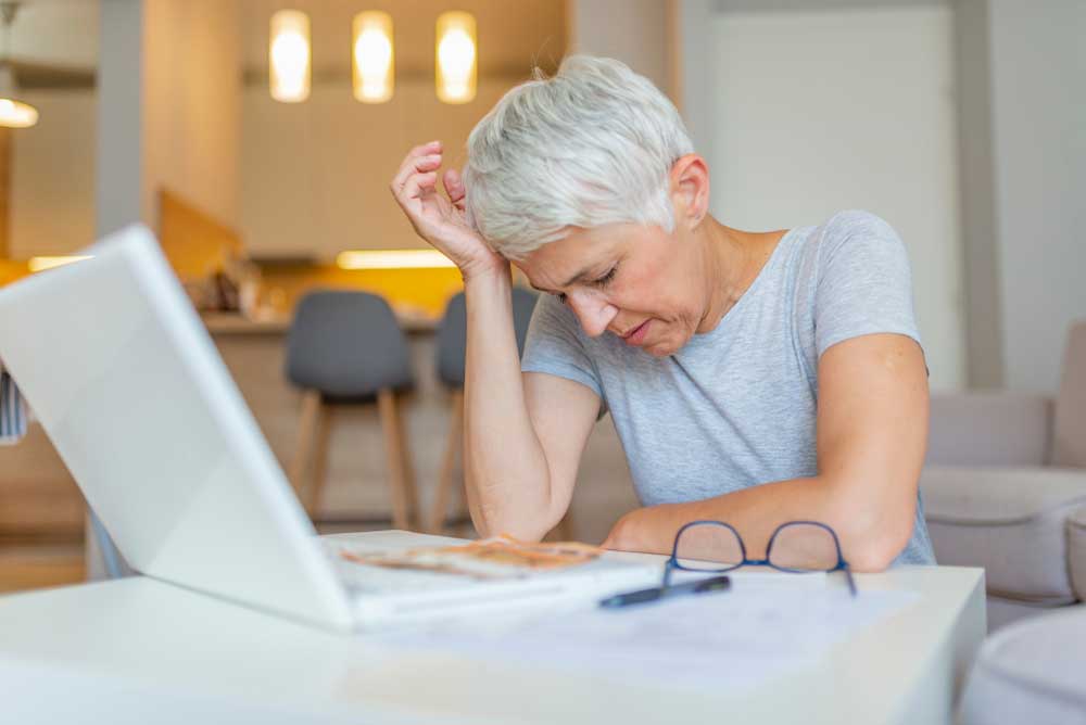 Worried woman sitting in front of laptop