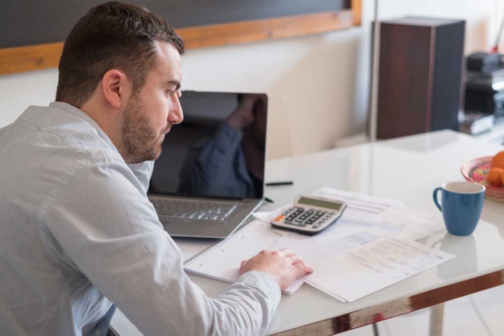 Man sitting at desk going though his financials