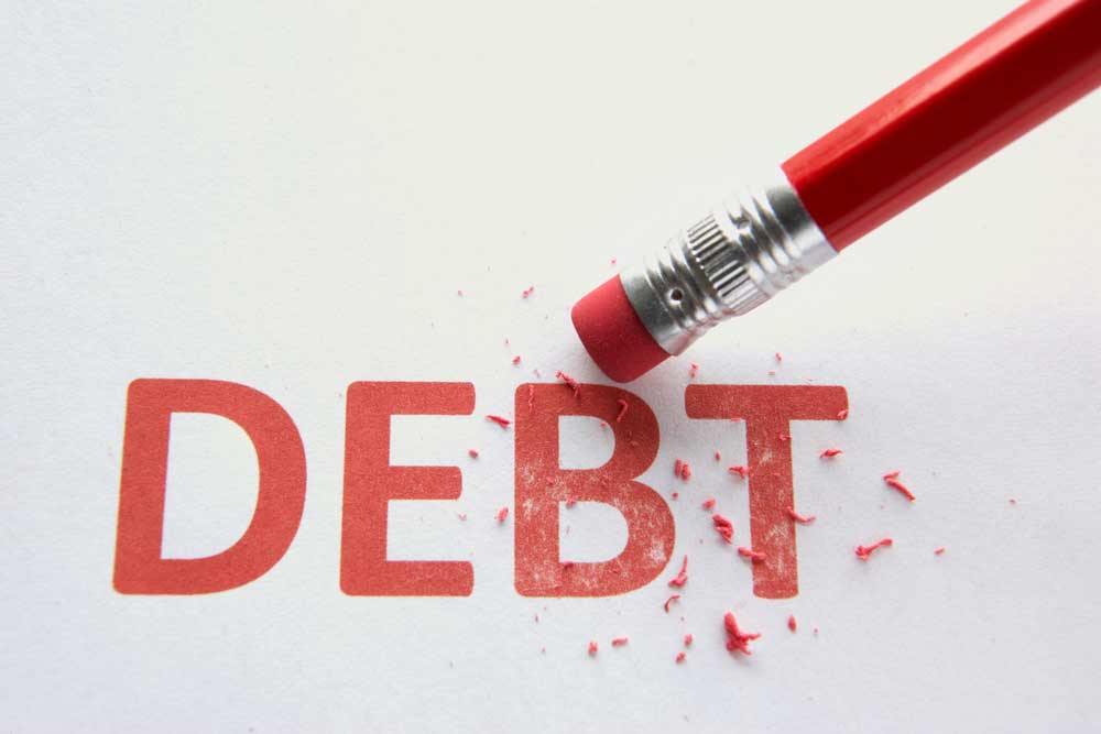 Eraser on pen erasing the word "debt" on a piece of paper