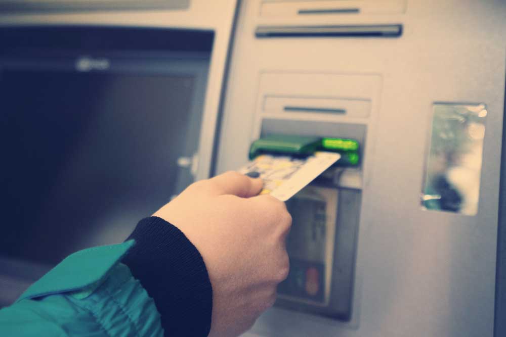 Hand inserting credit card into an ATM