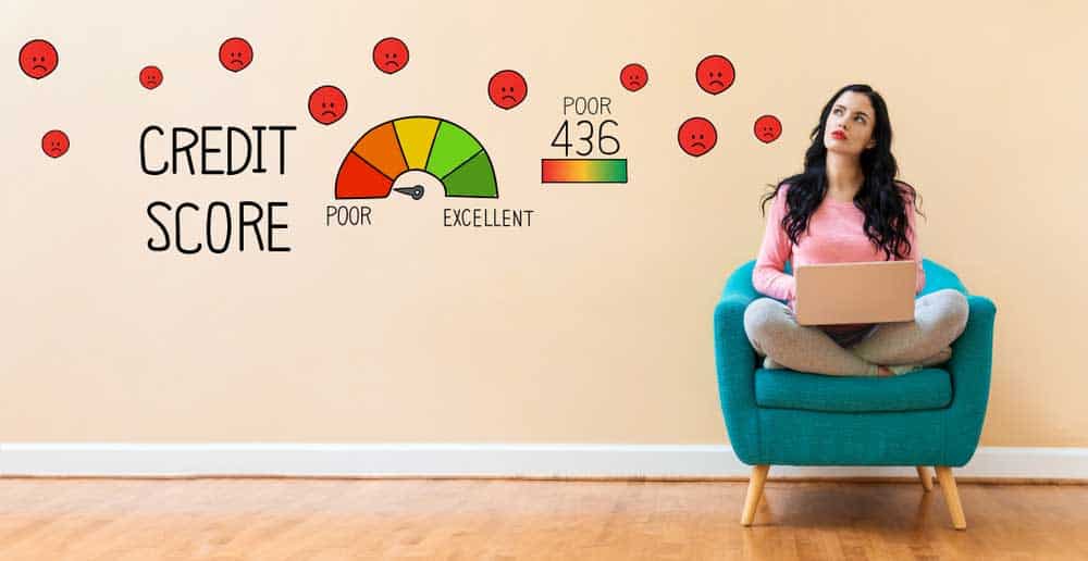 Woman sitting in chair in front of wall showing credit score