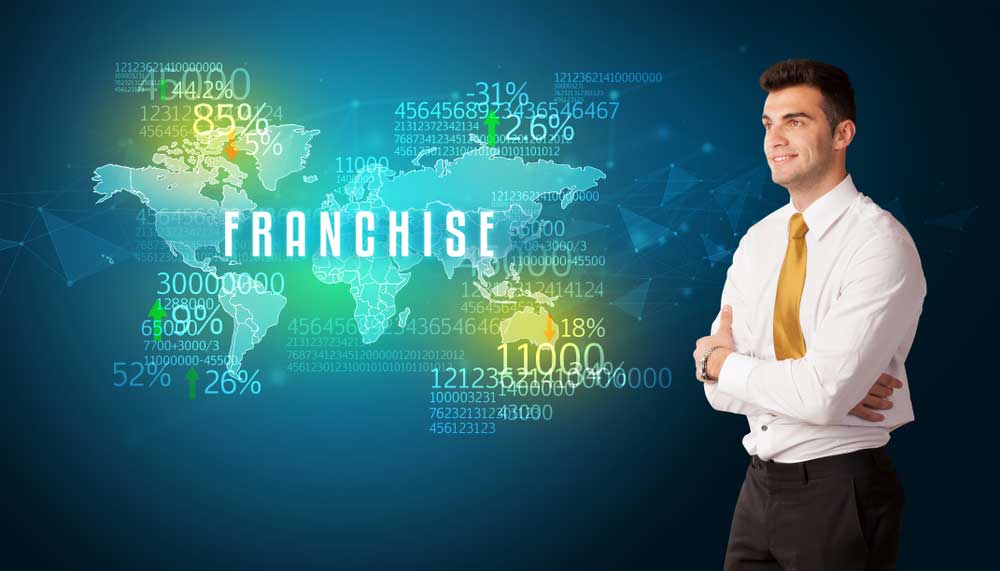 Businessman in front of a large world map with the word "franchise"