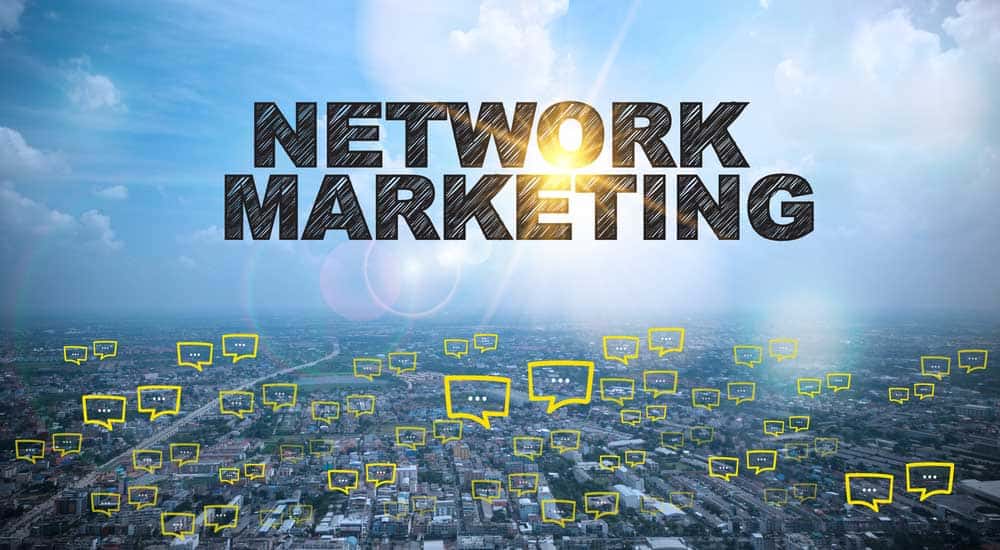 Overview of a large city with the words "network marketing" written in the sky