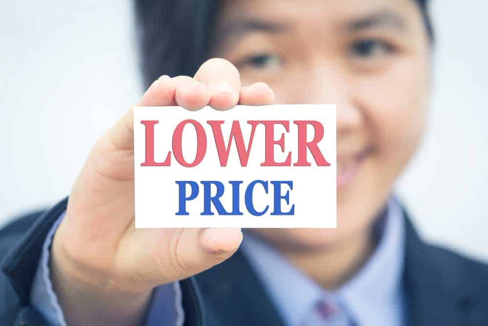 Asian business woman holding a sign saying "lower price"