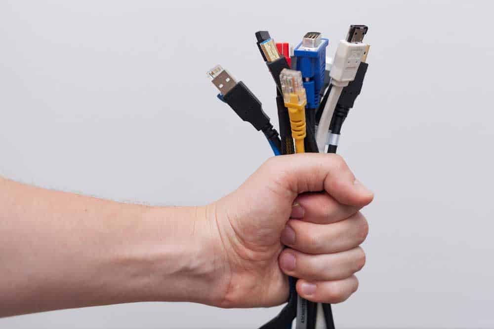 Male hand holding a number of computer cables