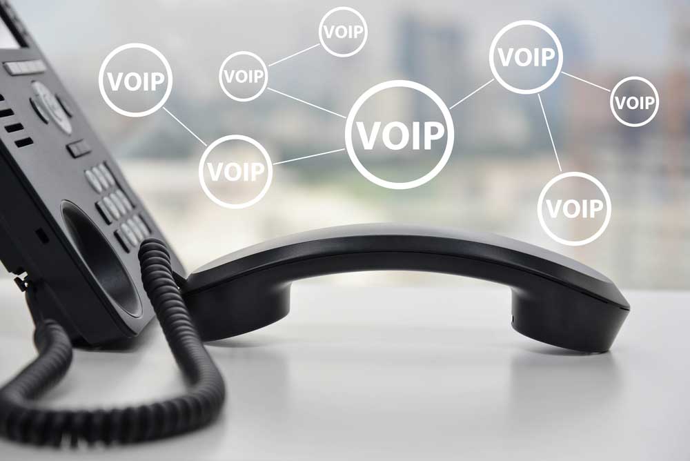 Phone on a table and VOIP (Voice over IP) written in circles