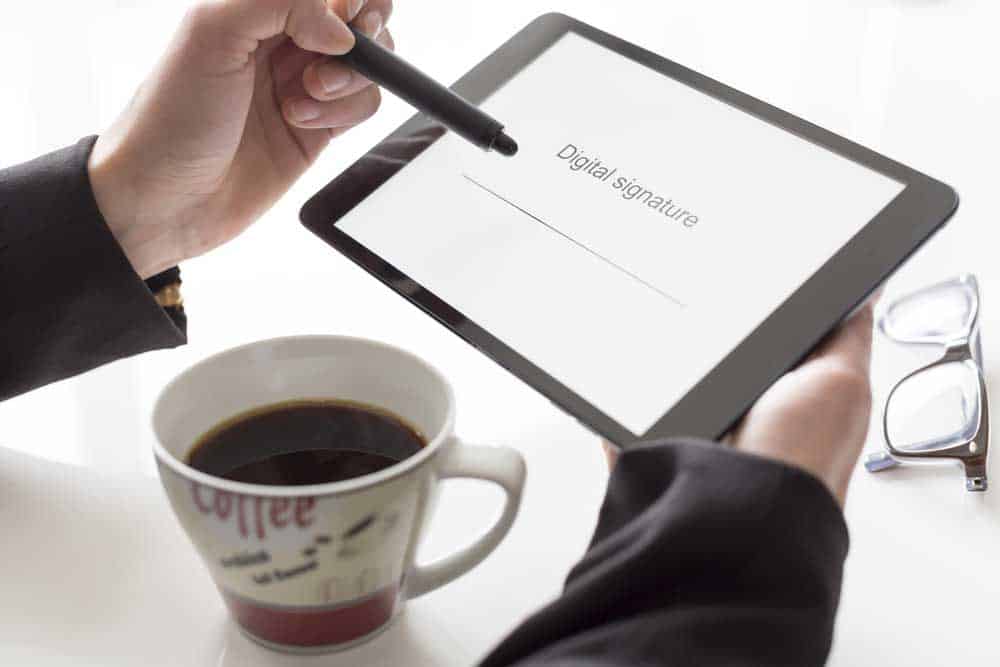 Businessman holding a tablet with the words "Digital signature".