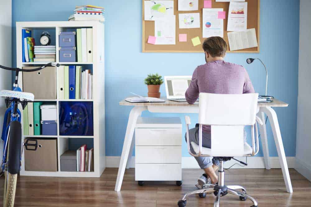 Man working in his office surrounded by home office furniture.