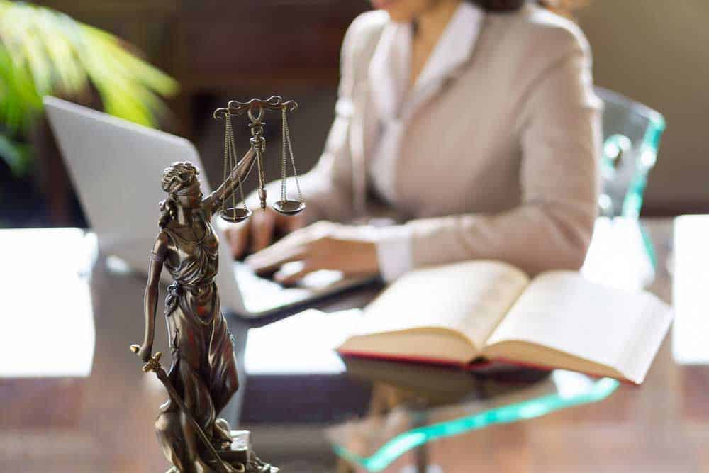 Lawyer working in her office with the Statue of Justice in front.