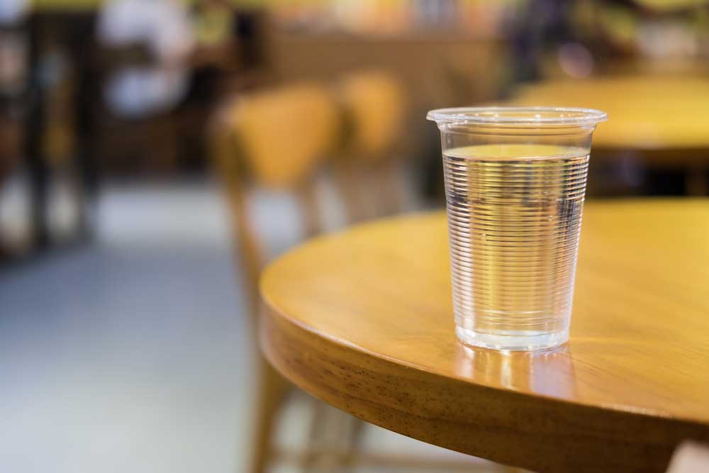 Filled plastic cup on a wooden table.